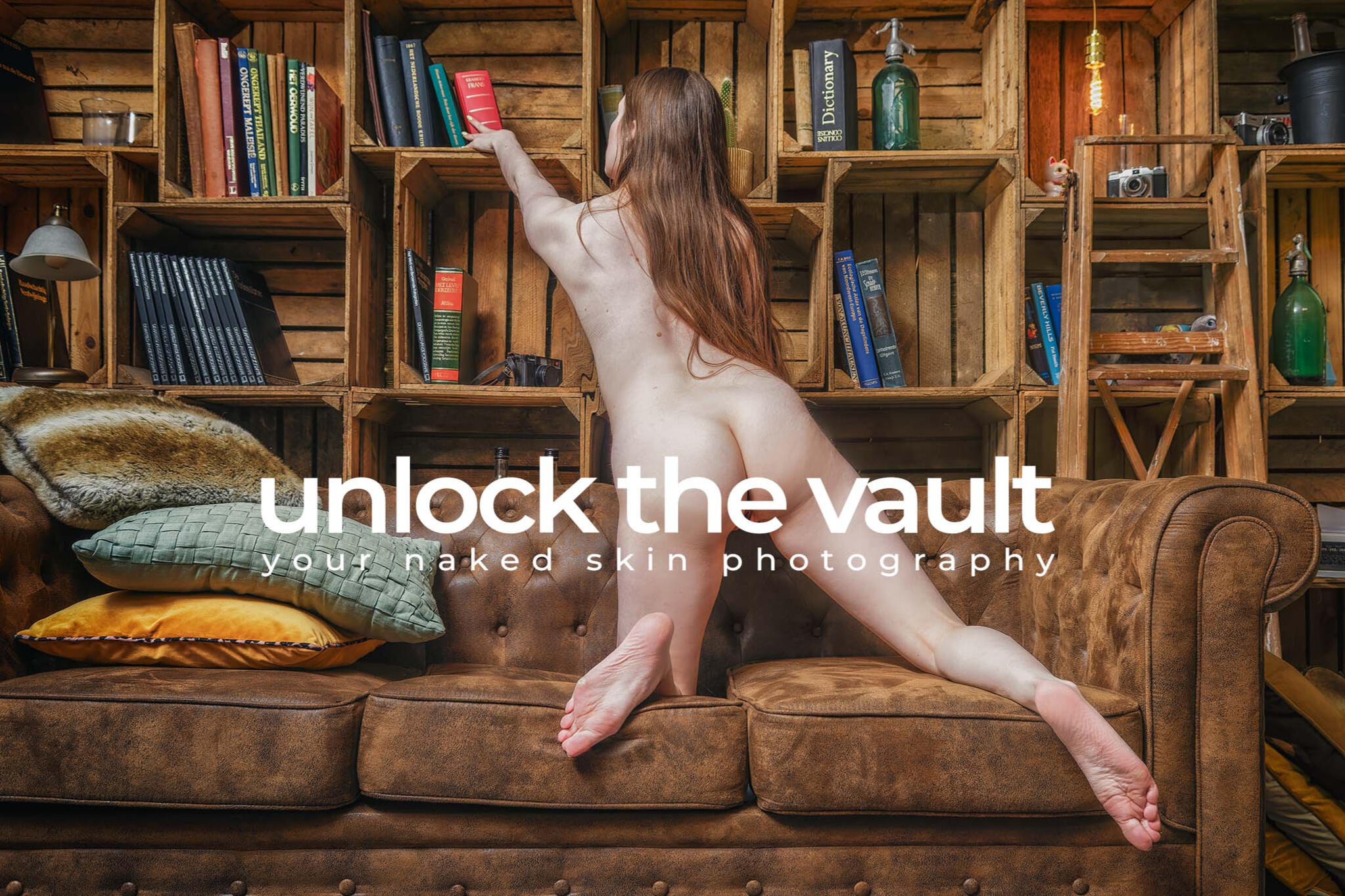 Ivy red lying naked on a brown couch with a book beside her. Photography by Your Naked Skin